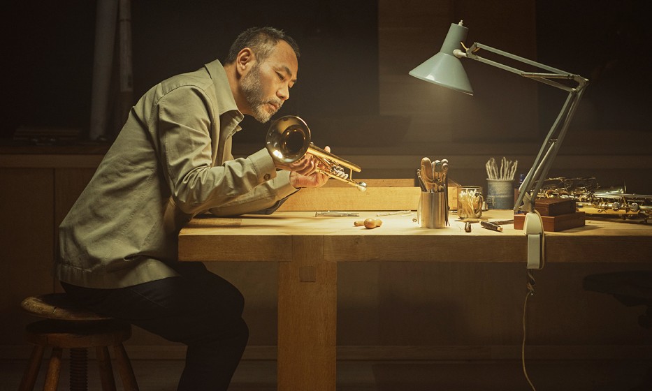 Man inspecting a trumpet he has made
